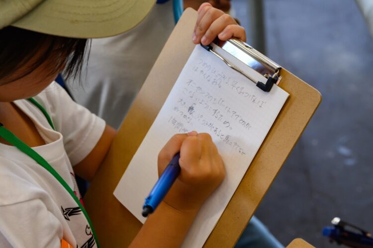 メモをとるこども記者の写真