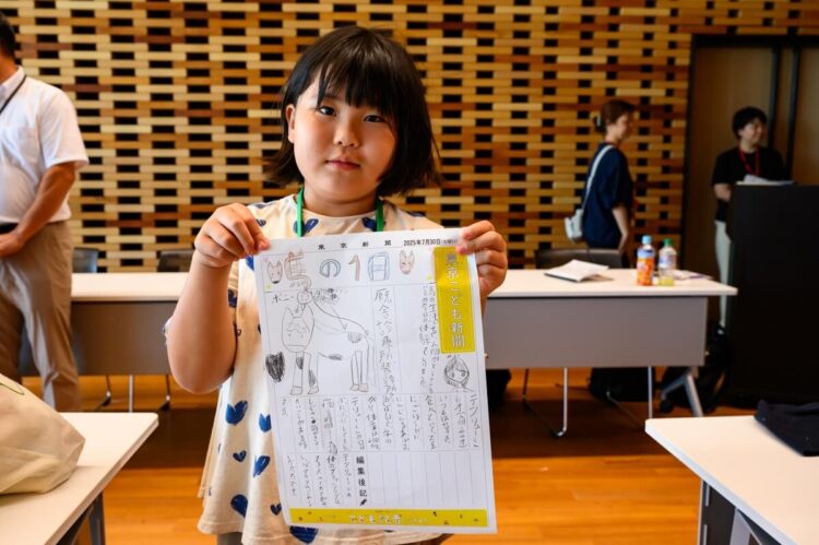 こども記者が新聞をもつ写真