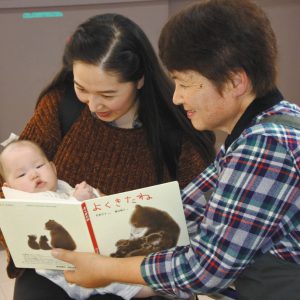 写真　ボランティア（右）から本を紹介してもらうチンさん母娘＝茨城県牛久市で