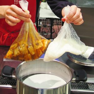 写真　「お湯ポチャ料理」で麻婆高野豆腐とご飯を作る今泉マユ子さん＝東京都内で
