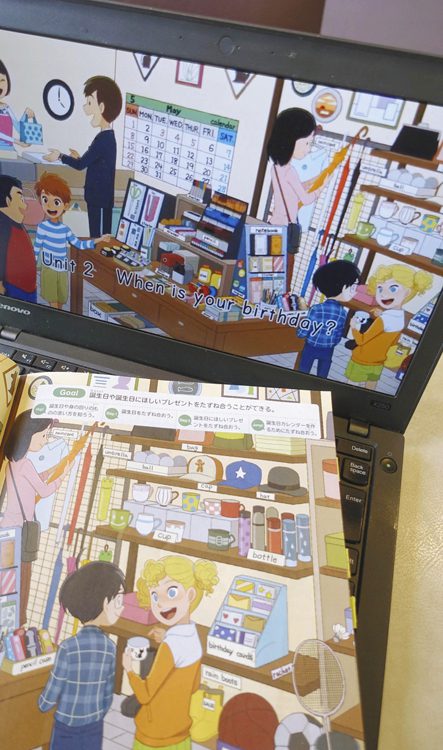 写真　2次元コードをタブレット端末などで読み込むと、アニメーションが見られる5年の英語のある教科書