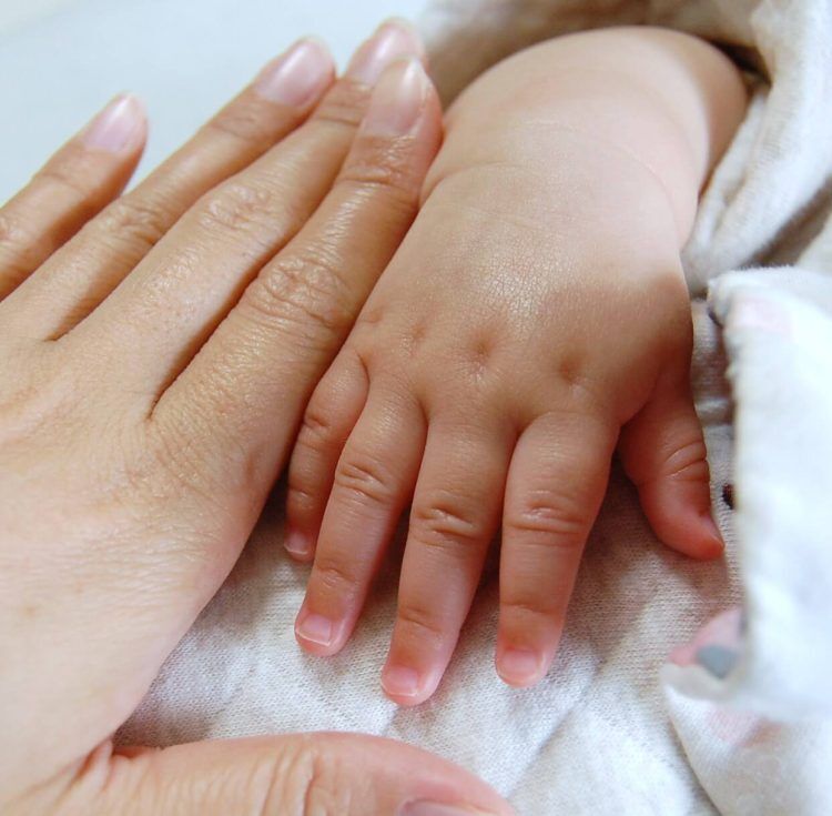 赤ちゃんと母親の手の写真